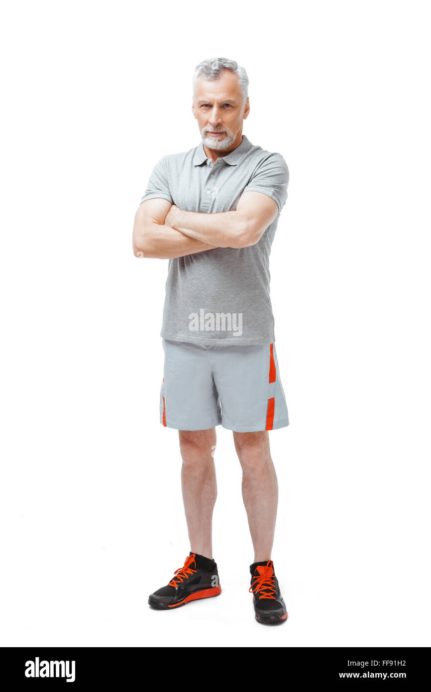 Vertikale Foto von silbernen Haaren senior Sportler isoliert auf weißem Hintergrund. Blick in die Kamera Mann Stockfoto