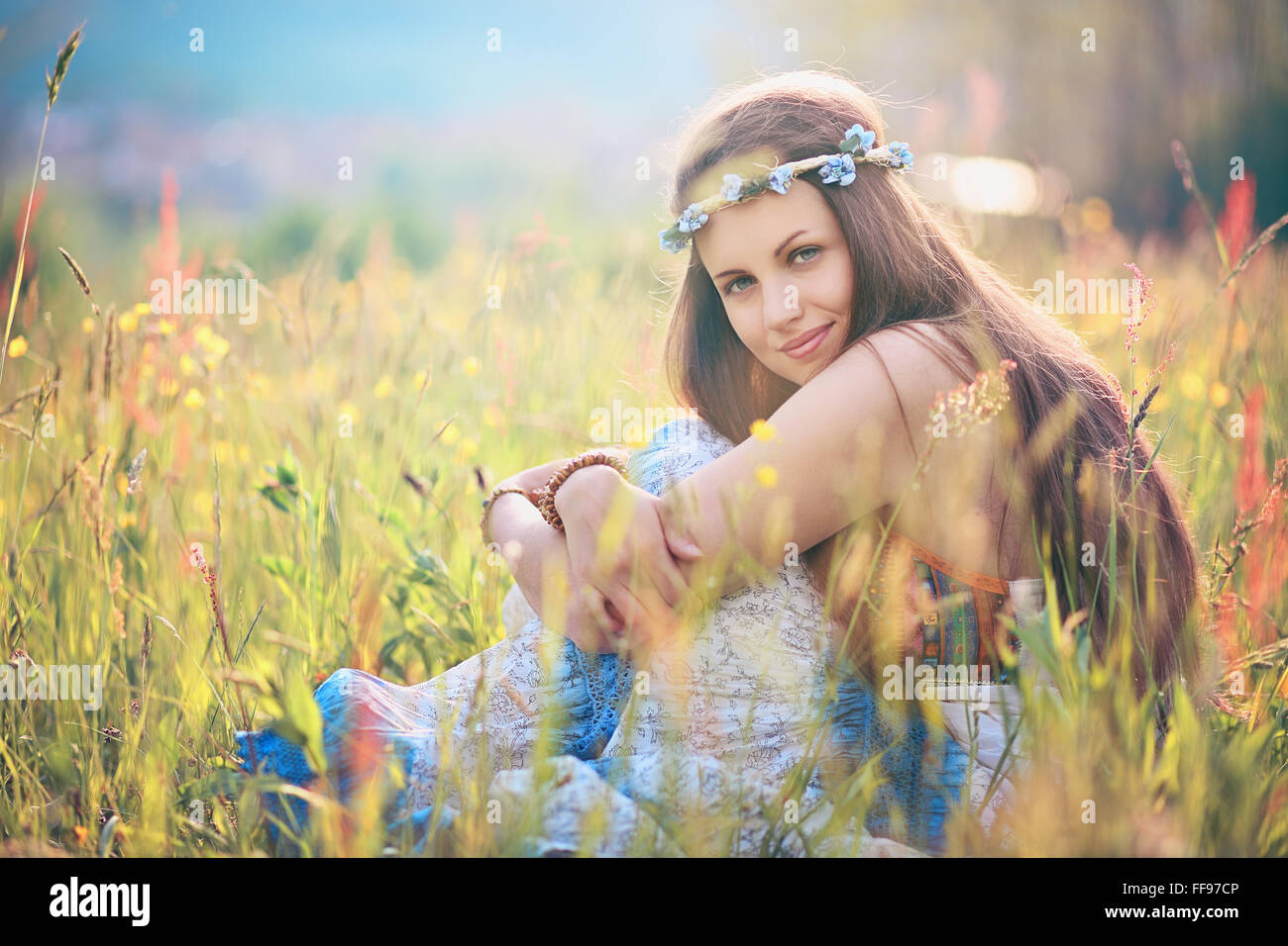 Schöne romantische Frau in Blumenwiese. Hippie und Zigeuner Kleid Stockfoto