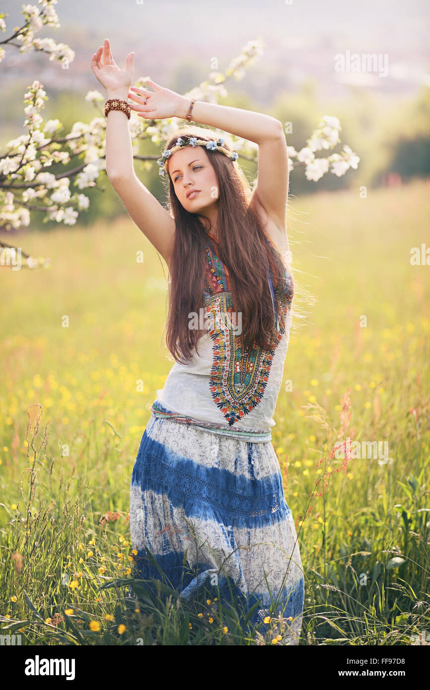 Wunderschöne Hippie-Frau tanzt in einer Sommerwiese. Freiheit und Harmonie Stockfoto