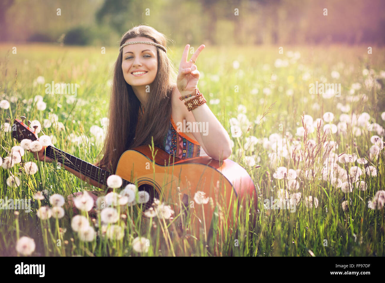 Lächelnde Hippie-Frau mit Peace-Zeichen. Freiheit und Harmonie Stockfoto