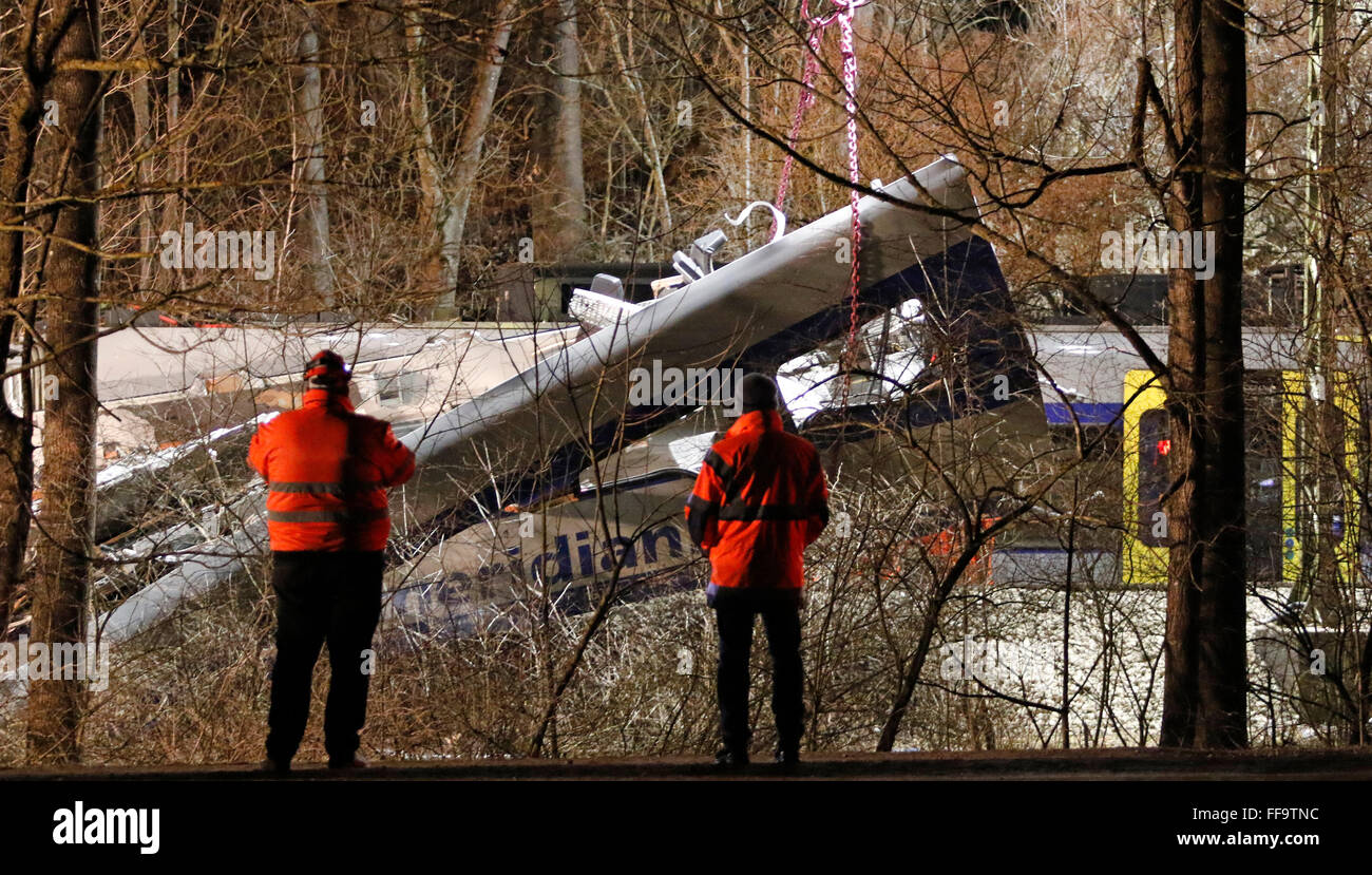 Bad Aibling, Deutschland. 11. Februar 2016. Einsatzkräfte, die gerade ein Spezialkran Aufhebung einer Kutsche an der Unfallstelle in der Nähe von Bad Aibling, Deutschland, 11. Februar 2016. Der Unfall passierte in einem Wald in der Nähe einer Klippe, die fällt auf einen Kanal und ist schwer zu erreichen. Elf Menschen starben bei dem schweren Zugunglück in Oberbayern, während viele weitere wurden verletzt. Foto: UWE LEIN/Dpa/Alamy Live News Stockfoto