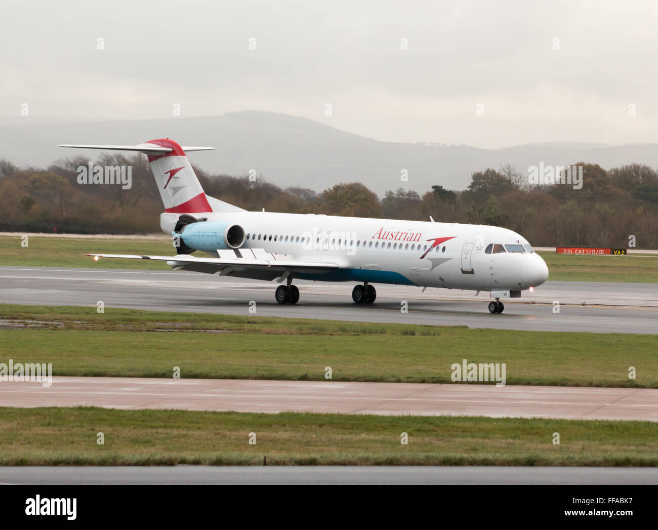 Austrian Airlines Fokker 100 mittelständische Twin-Turbinen-Kreiselbegläse Passagierflugzeug auf Manchester International Airport Asphalt Rollen. Stockfoto