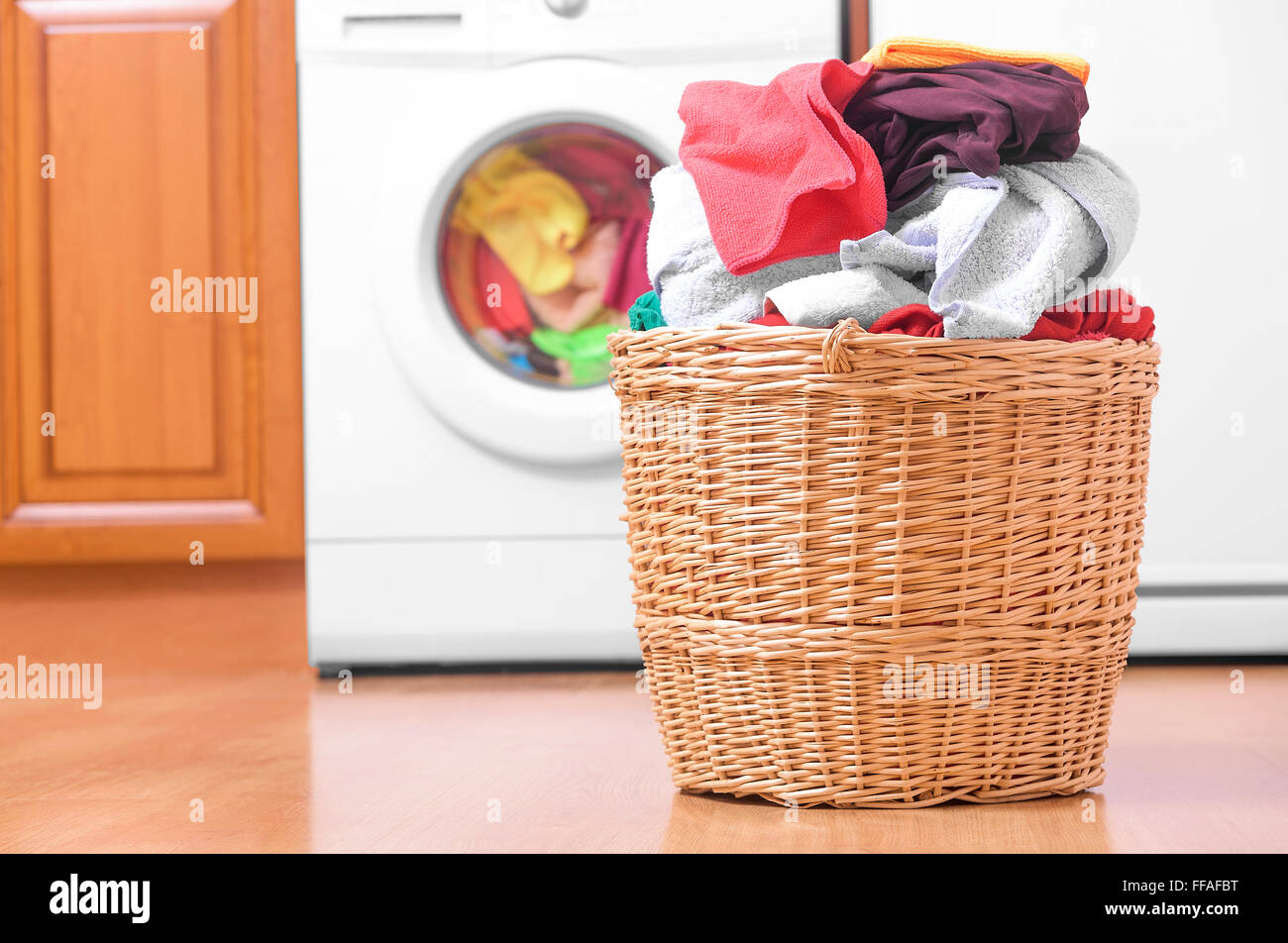 Korb mit Wäsche und Waschmaschine. Stockfoto