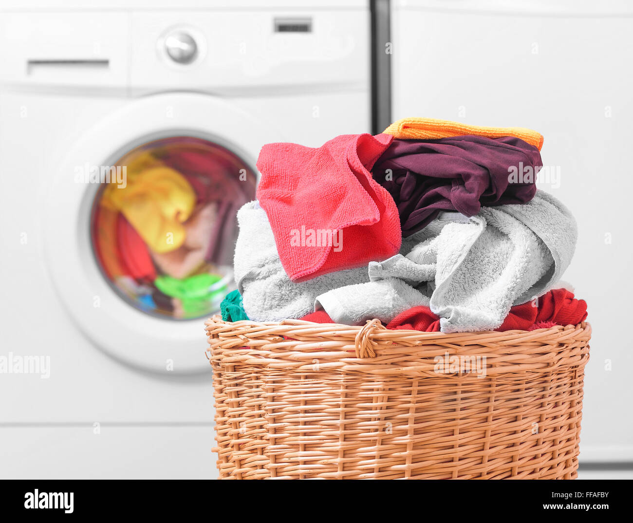 Korb mit Wäsche und Waschmaschine. Stockfoto