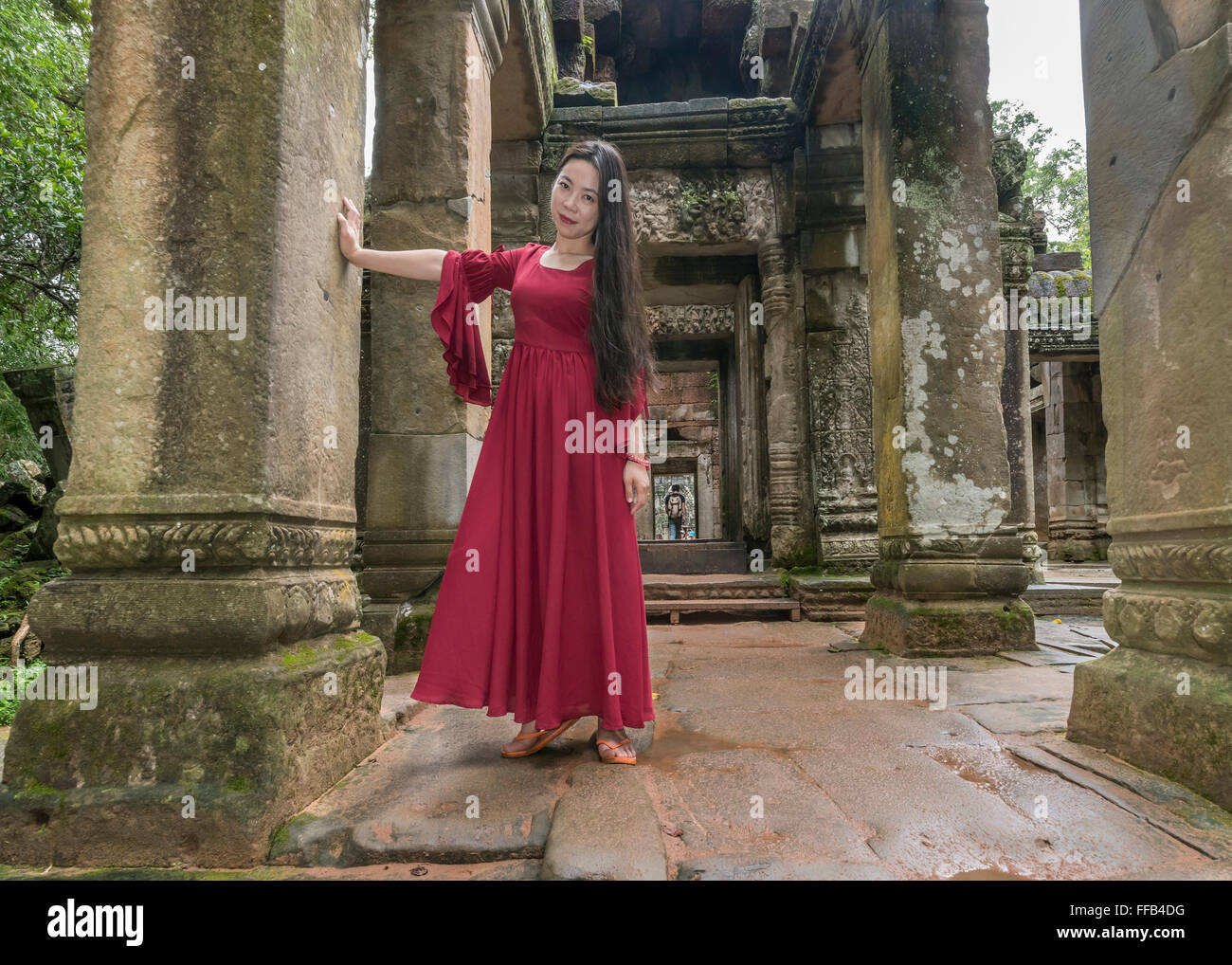 Mädchen in einem roten Kleid, East Gate, Ta Prohm Tempel, Angkor Thom, Siem Reap, Kambodscha Stockfoto