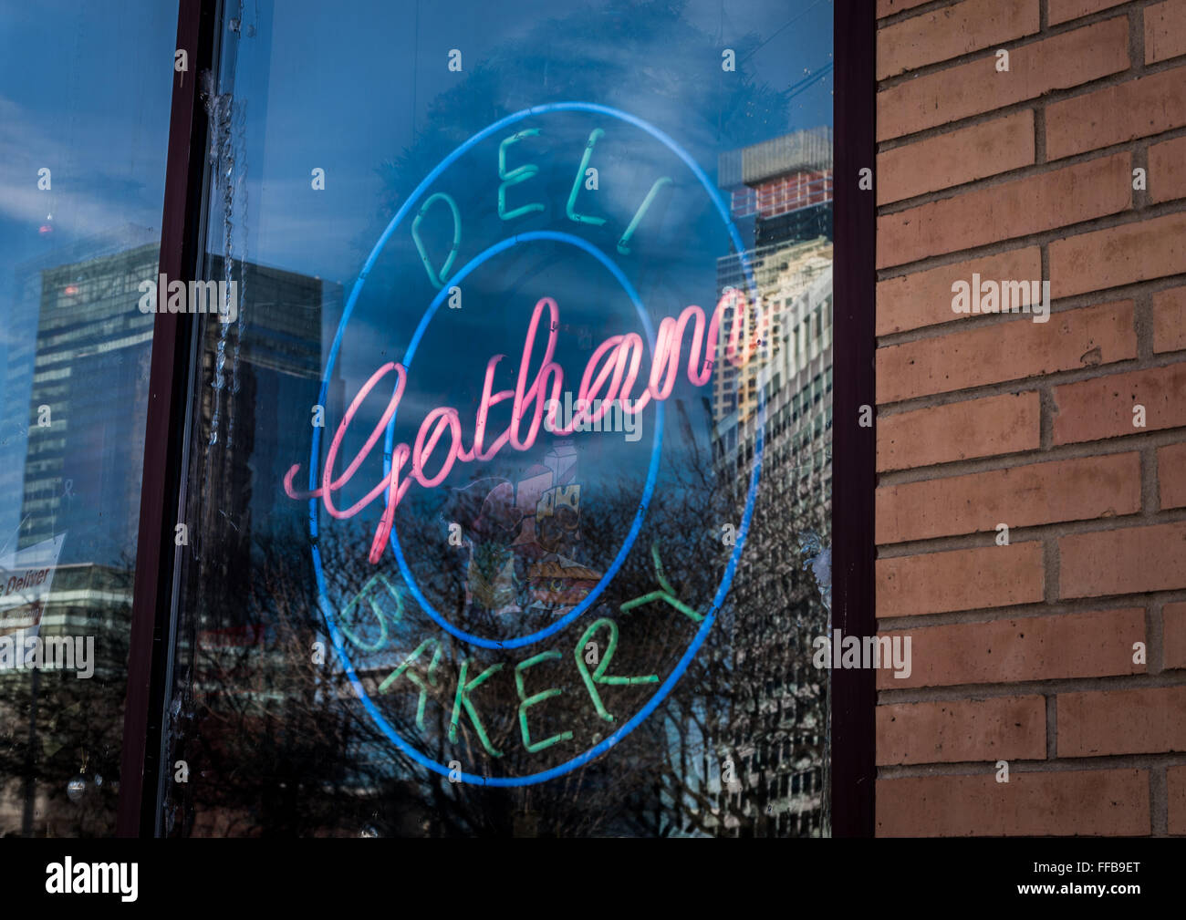 Neon-Schild im Fenster der Gotham Deli und Bäckerei in Jersey City mit Reflexionen von den Türmen gegenüber im Glas. Stockfoto