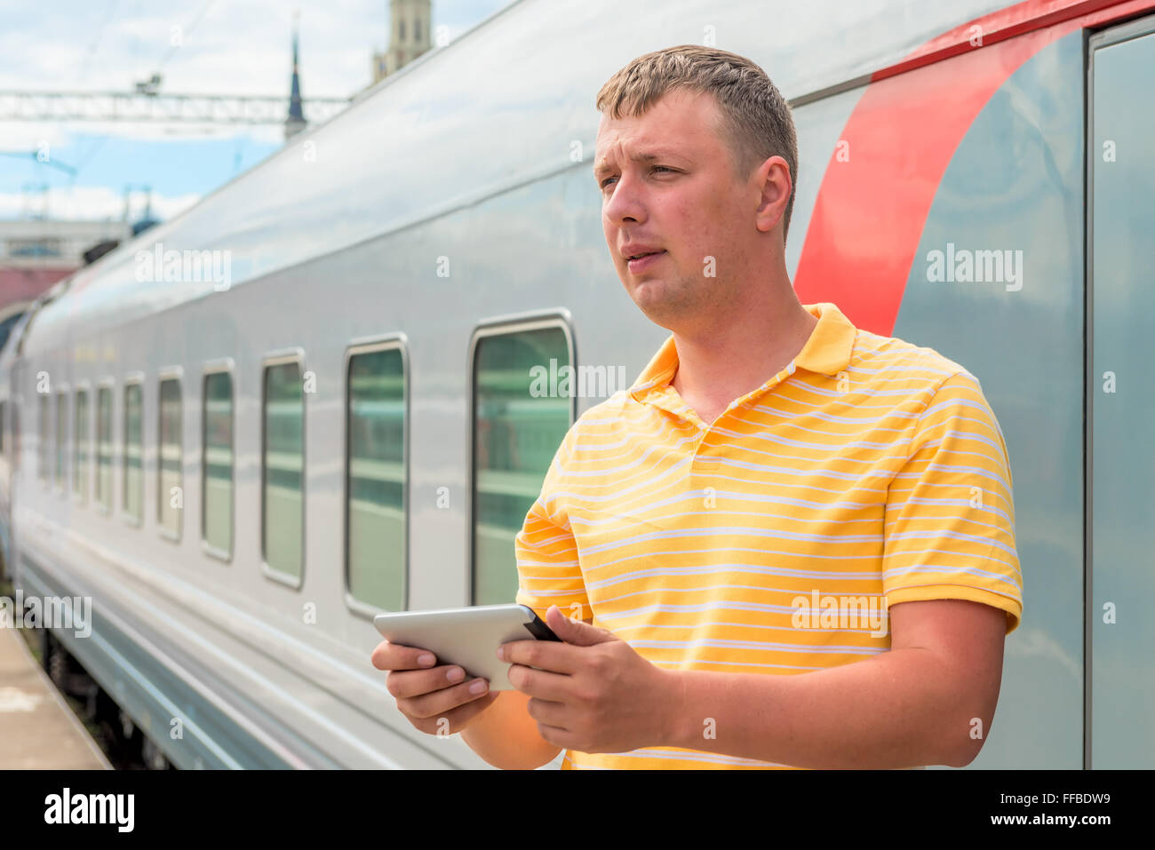 Mann mittleren Alters mit einem Tablet neben dem Zug Stockfoto