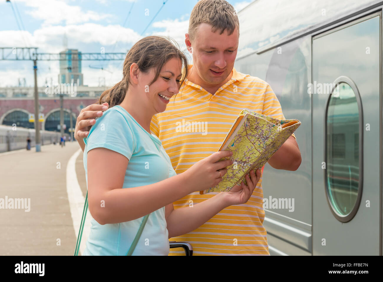glückliches Paar wählt eine Anfahrtsskizze für die Reise im Zug Stockfoto