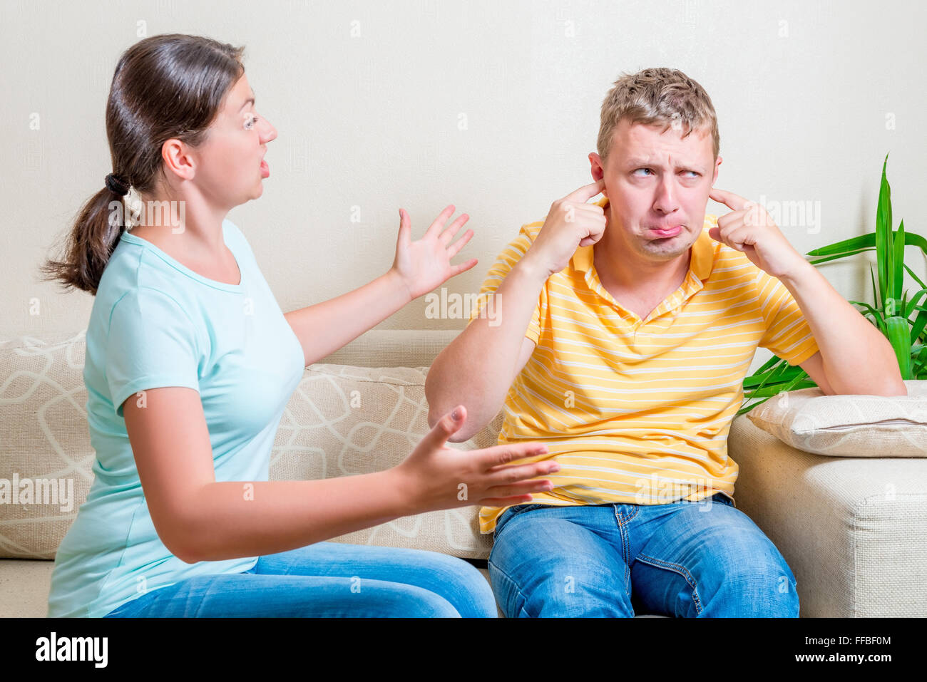 Frau schimpft mit ihr Mann sitzt auf einem Sofa im Wohnzimmer Stockfoto