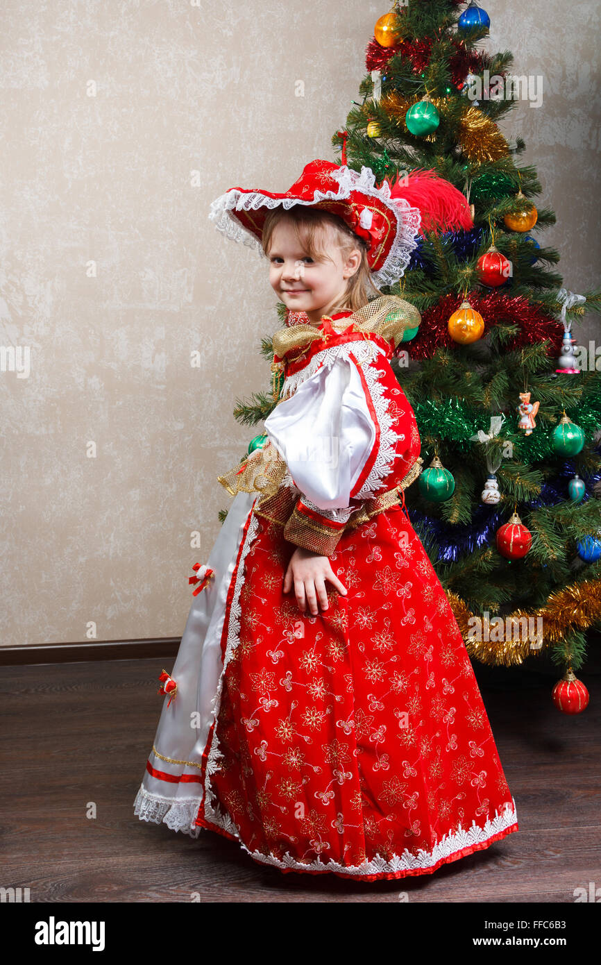 kleines Mädchen im Karnevalskostüm dem Weihnachtsbaum Stockfoto
