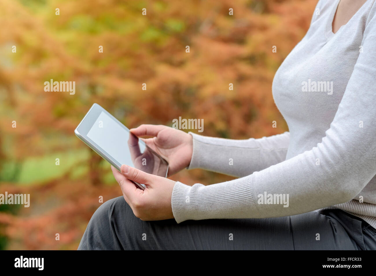 Frau mit einem Tablet-PC im Herbst park Stockfoto