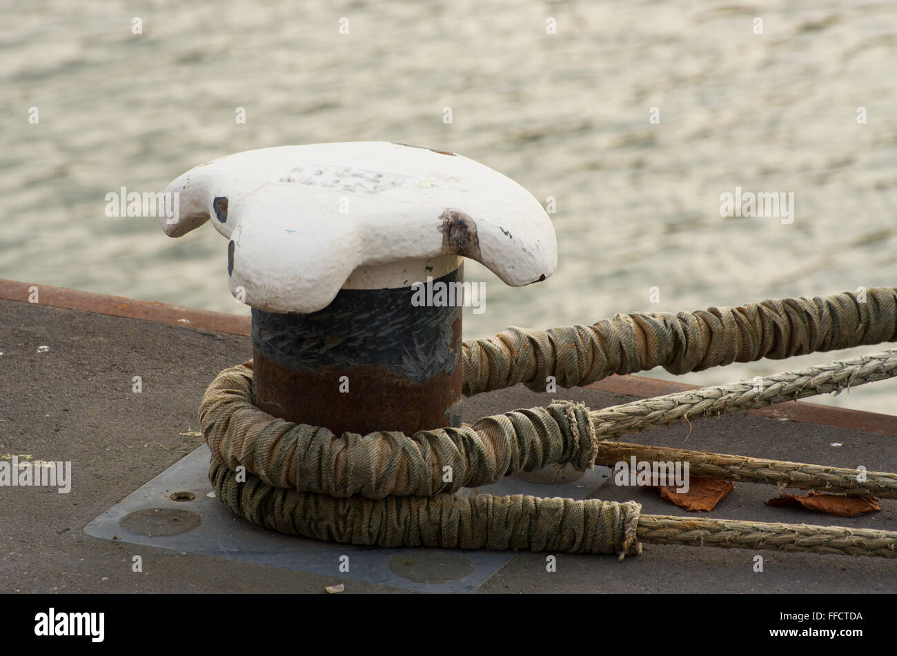 Maritime Poller am Kai mit Seil Stockfoto