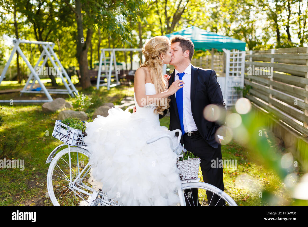 Hübsche junge Braut und Bräutigam mit Retro-Bike in einem grünen park Stockfoto