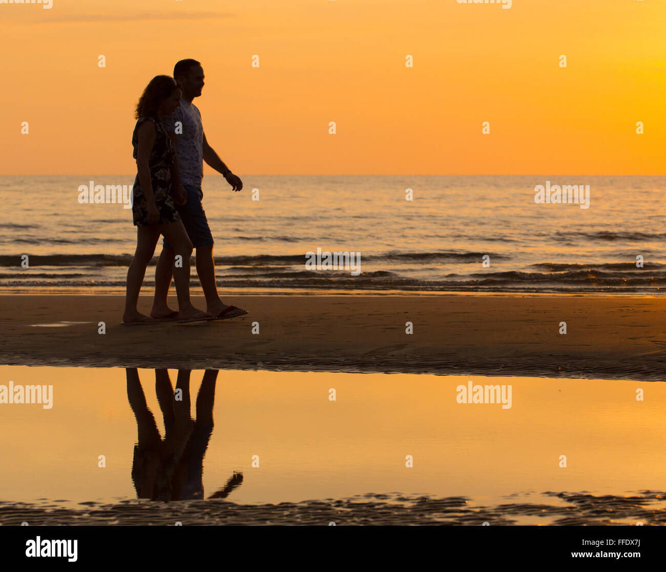 Paare, die am Strand bei Sonnenuntergang, Sabah, Malaysia Stockfoto