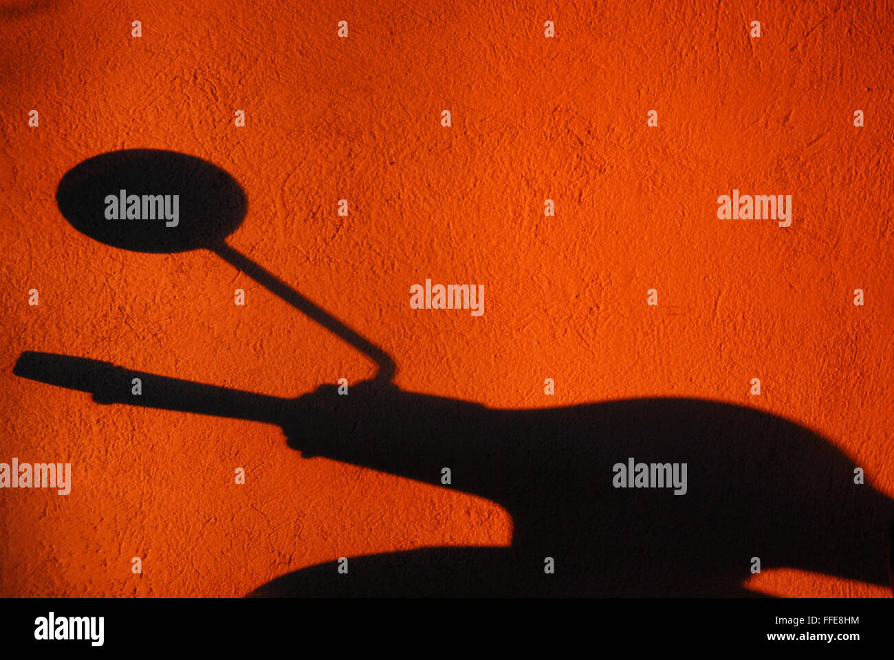 Der Schatten der Vespa, der berühmtesten Roller der Welt auf eine Wand mit warmen Abendlicht. Vespa ist italienische Spitzenprodukt Stockfoto