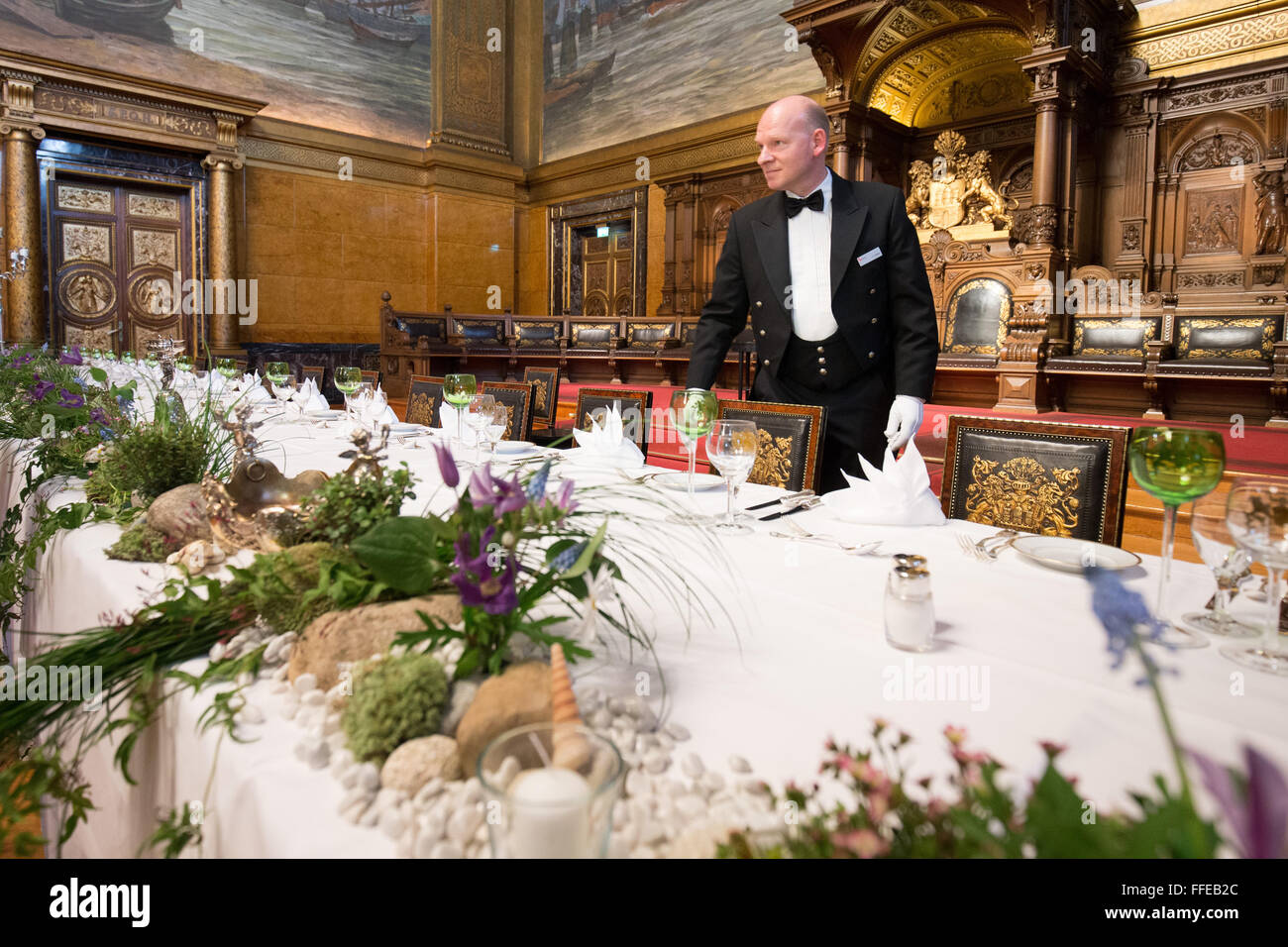 Der Leiter des Festgelages Arrangements, Carsten Rogge, deckt den Tisch für die Ehrengäste bei den Vorbereitungen für das so genannte traditionelle Matthiae-Mahl-Dinner im Rathaus in Hamburg, Deutschland, 12. Februar 2016. Abgela Bundeskanzlerin Merkel und der britische Premierminister James Cameron sind den geladenen Ehrengästen Ehrengast bei der traditionellen Dinner-Event. Das Matthiae-Mahl-Dinner hat eine lange Tradition in der Hansestadt Hamburg, bis 1356 n. Chr. zurückreicht. Foto: CHRISTIAN CHARISIUS/dpa Stockfoto