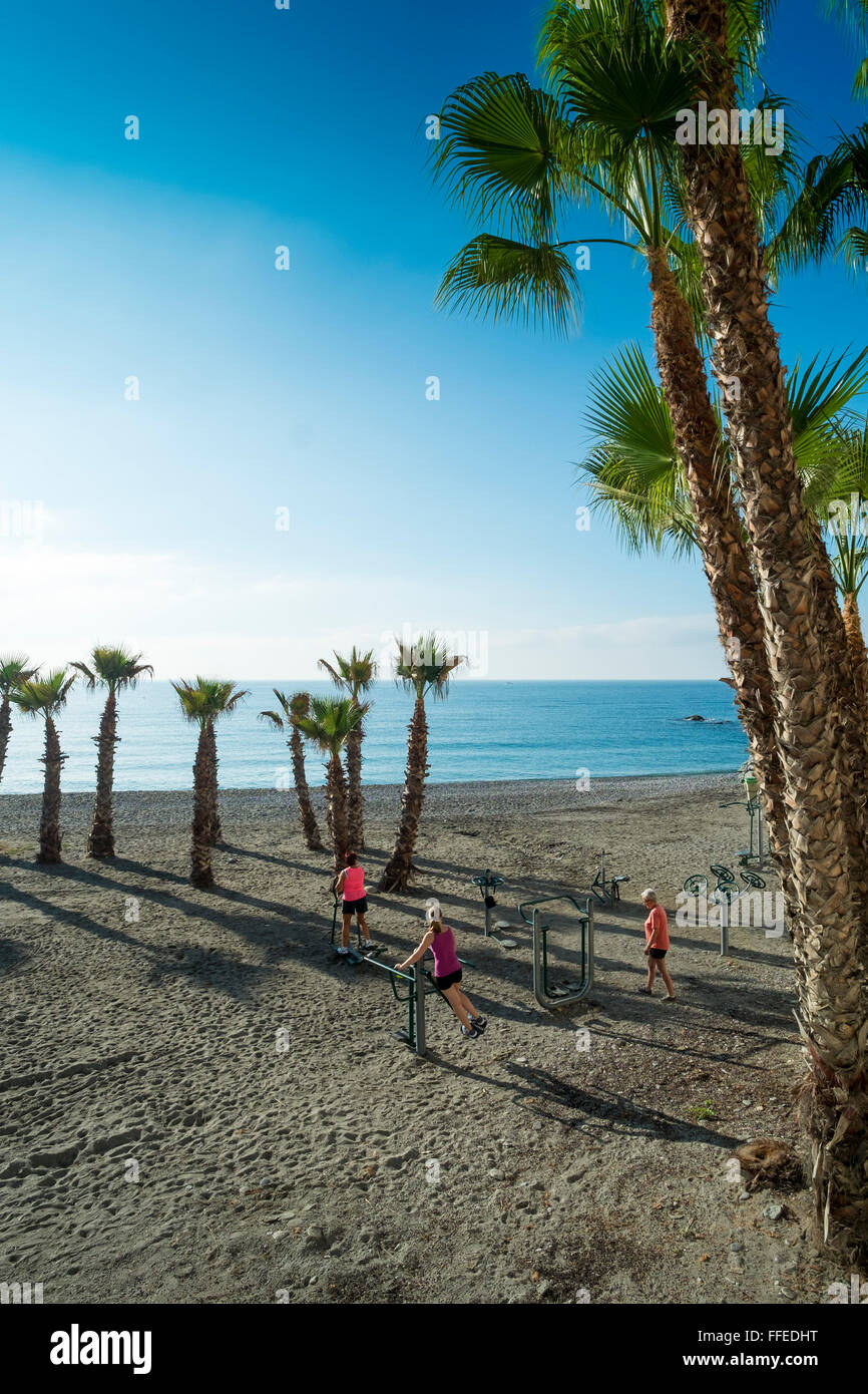 Menschen trainieren an der städtischen Ausrüstung am Strand, Playa del Mar, in der Herbstsonne. Almuñécar, Costa Tropical, Provinz Granada, Andalusien. Spanien Stockfoto