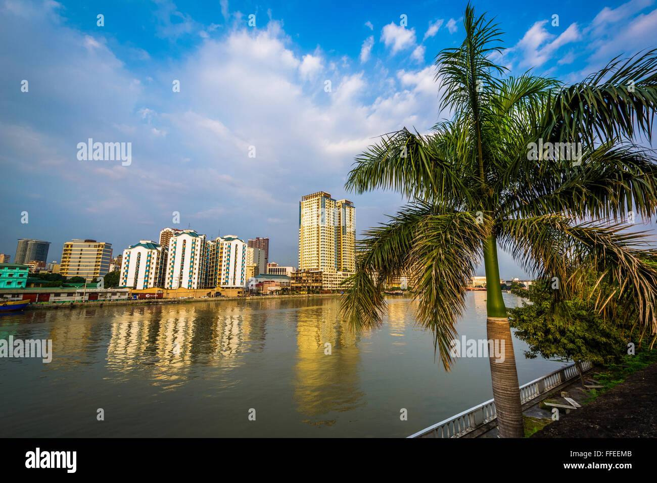 Palme und Gebäuden entlang des Flusses Pasig von Fort Santiago, in Intramuros, Manila, die Philippinen gesehen. Stockfoto