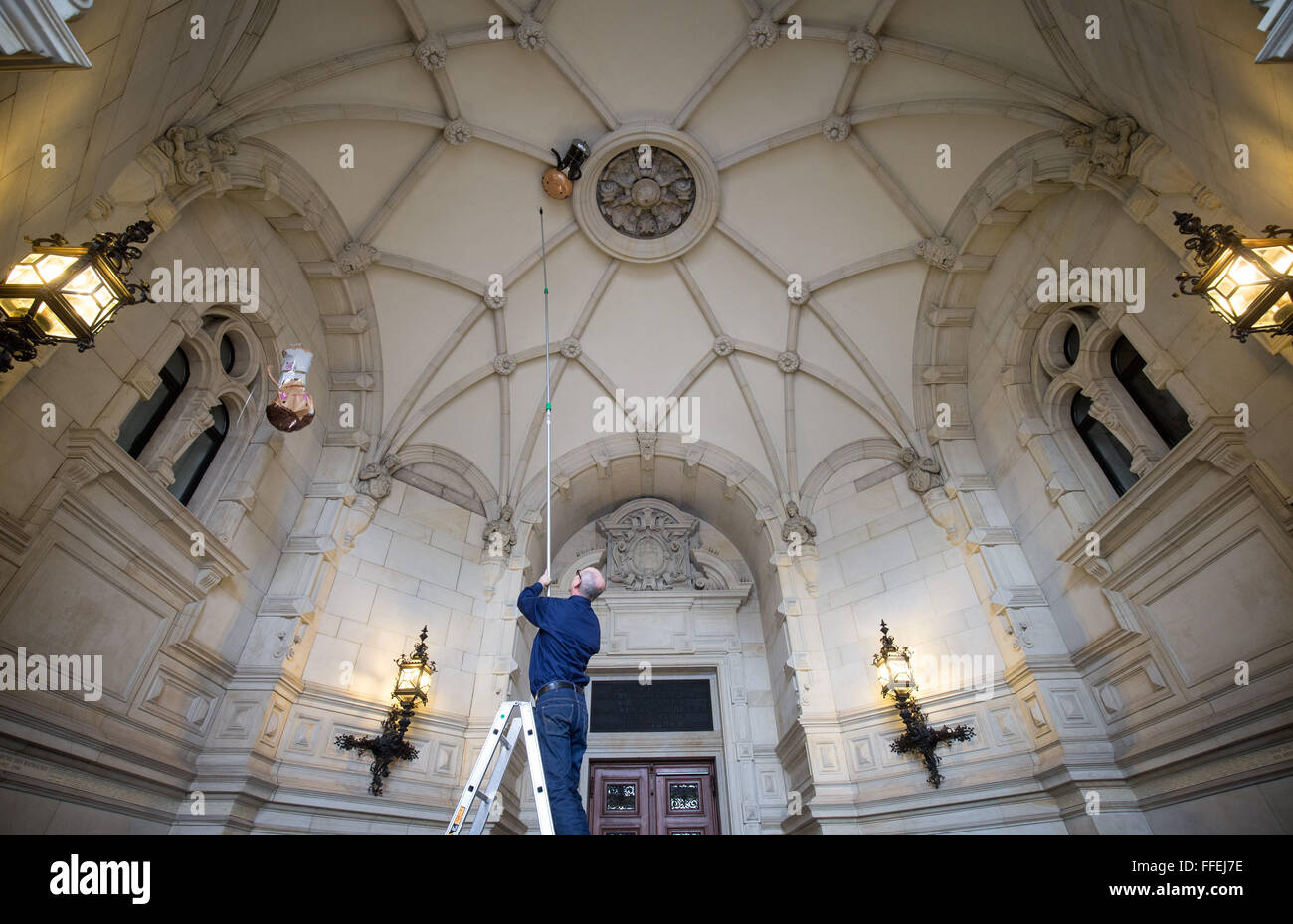 Hamburg, Deutschland. 12. Februar 2016. Ein Mitarbeiter des Rathauses entfernt zwei gefüllte Heliumballons ein Hochzeitspaar, während die letzten Vorbereitungen für das so genannte traditionelle Matthiae-Mahl-Dinner im Rathaus in Hamburg, Deutschland, 12. Februar 2016. Abgela Bundeskanzlerin Merkel und der britische Premierminister James Cameron sind den geladenen Ehrengästen Ehrengast bei der traditionellen Dinner-Event. Das Matthiae-Mahl-Dinner hat eine lange Tradition in der Hansestadt Hamburg, bis 1356 n. Chr. zurückreicht. Foto: CHRISTIAN CHARISIUS/Dpa/Alamy Live News Stockfoto