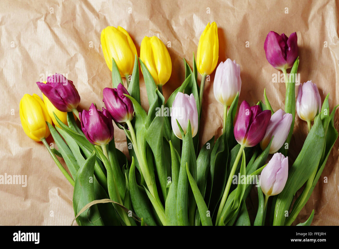 Frühlingsstrauß auf Handwerk Papierhintergrund, Tulpen Stockfoto