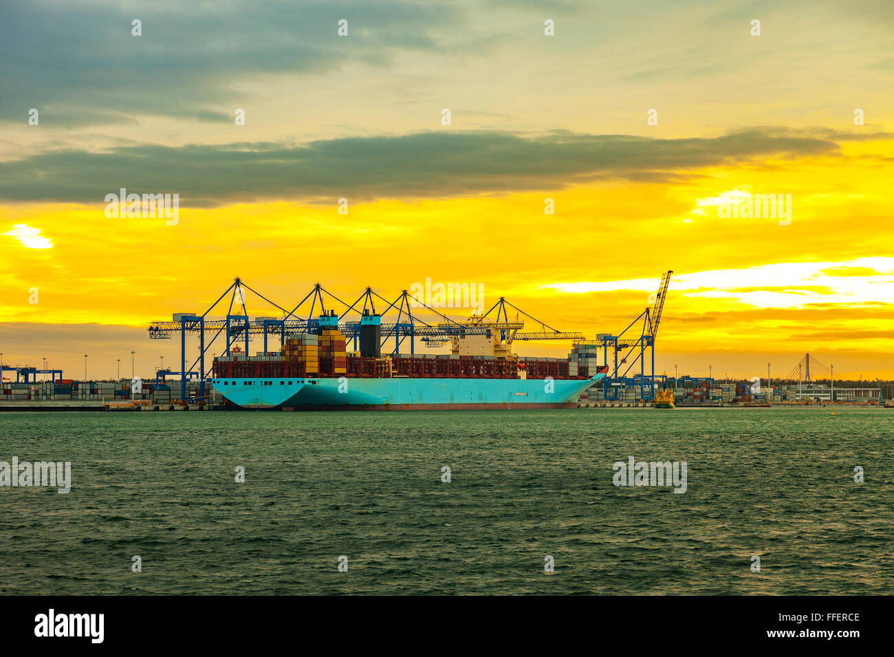Containerschiff bei Sonnenuntergang im Hafen von Danzig, Polen. Stockfoto