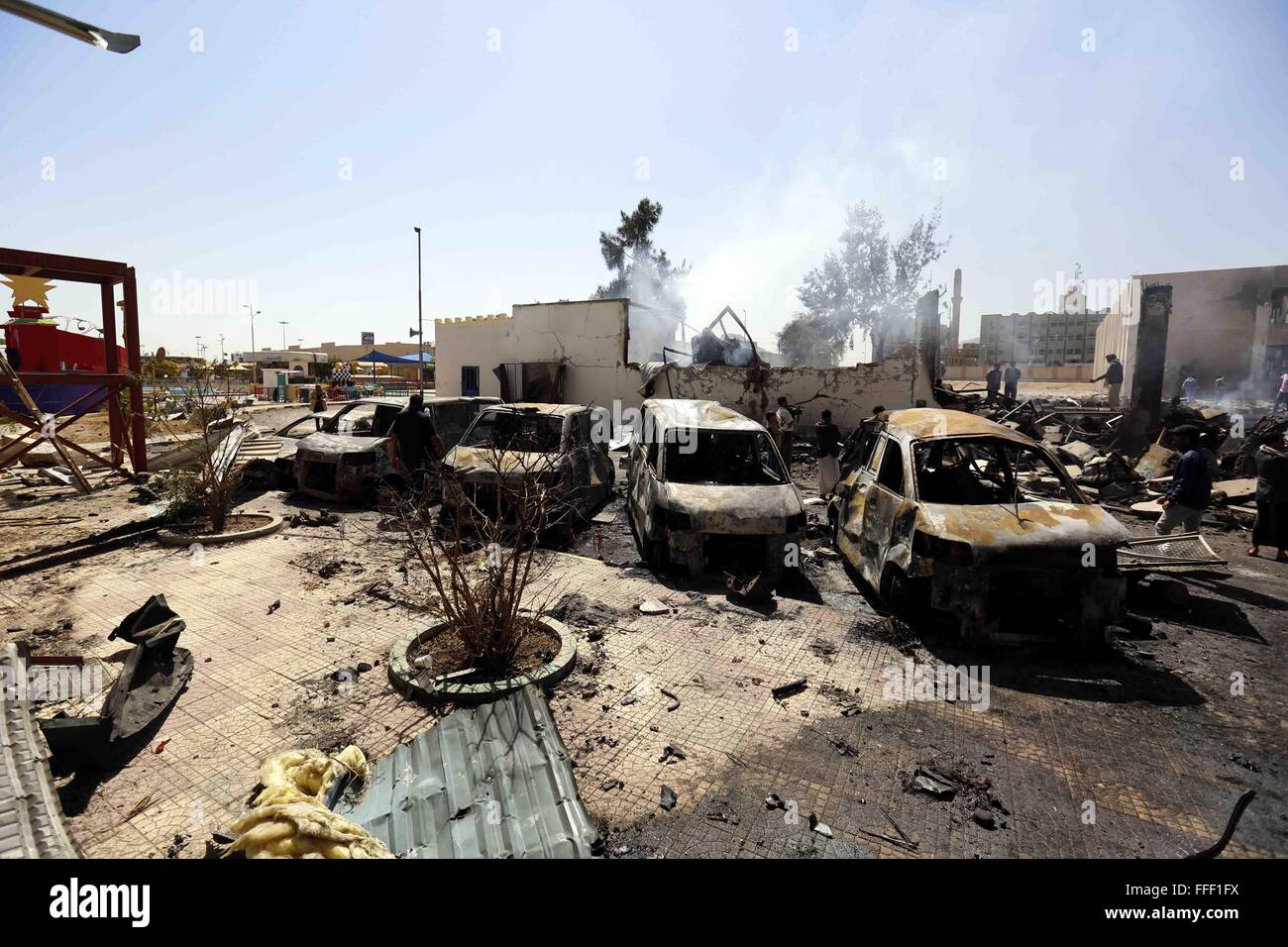 Sanaa, Jemen. 12. Februar 2016. Menschen untersuchen zerstörten Autos nach Luftangriffen durch die Saudi-geführten Koalition in Sanaa, Jemen, am 12. Februar 2016 durchgeführt. © Hani Ali/Xinhua/Alamy Live-Nachrichten Stockfoto