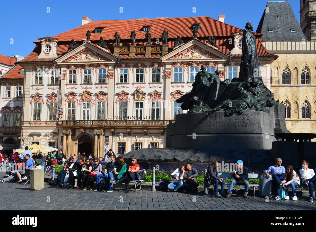 Touristen sitzen vor dem Jan-Hus-Denkmal am Altstädter Ring in Prag, Tschechien. Stockfoto