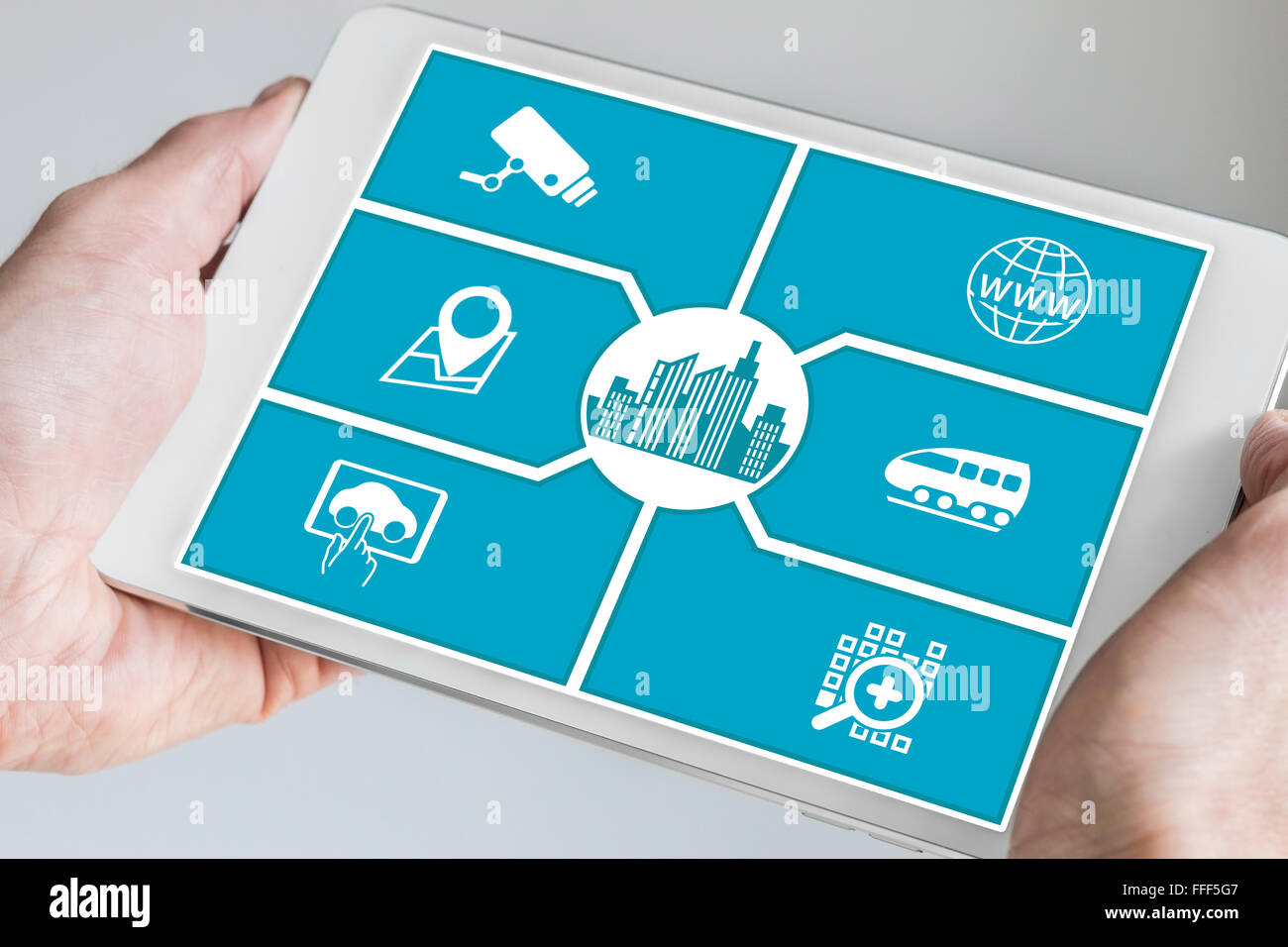 Smart City-Konzept. Hand mit Tablet oder Smartphone mit Ikonen der angeschlossenen Geräte. Stockfoto