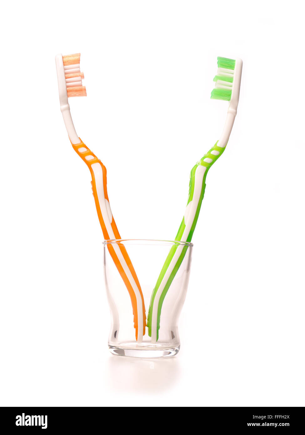 Zahnbürsten in einem Glas auf weiß Stockfoto