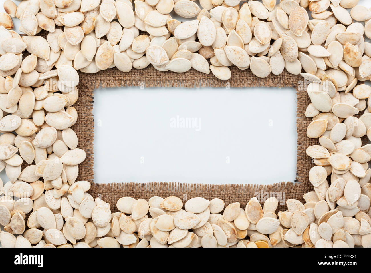 Gestell aus Sackleinen und Kürbis Samen liegt auf weißem Hintergrund, mit Platz für Ihre Kreativität, text Stockfoto
