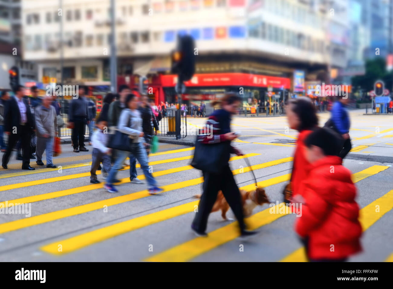 Tilt-Shift-Objektiv Unschärfe-Effekt. Hong Kong Stadtbild Ansicht. Menschen zu Fuß auf Kreuzung auf überfüllten Straßen mit Wolkenkratzern und shop Stockfoto