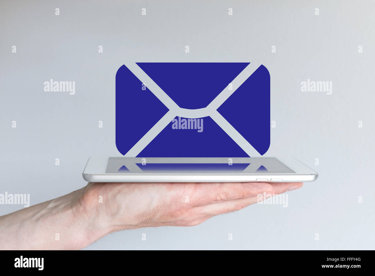 Mobile computing, e-Mail- und Collaboration-Konzept. Hand mit modernen Silber-weißen Tablet oder Smartphone. Blaue e-Mail-Symbol ein Stockfoto