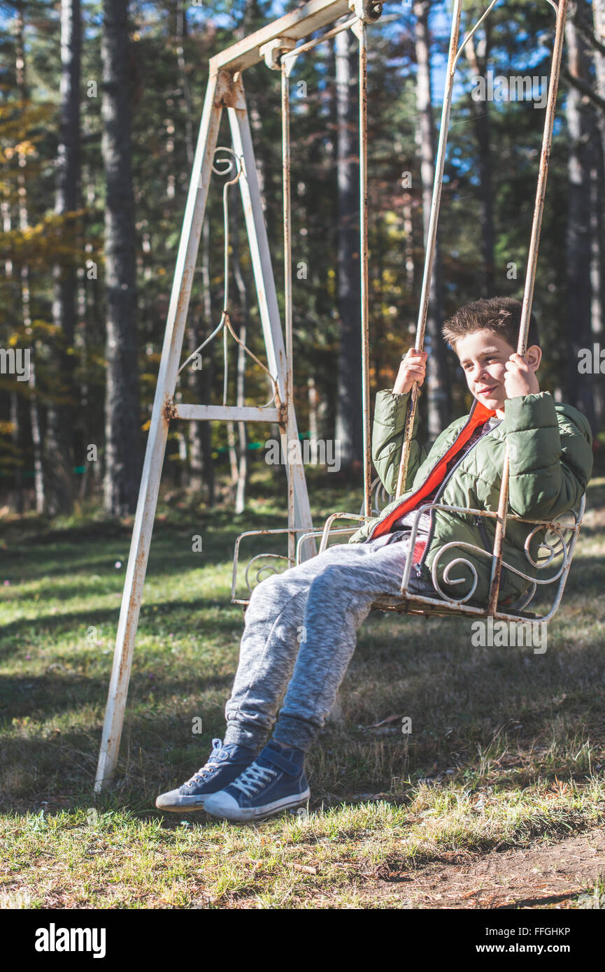 Kind auf einer Schaukel in einem Wald Stockfoto