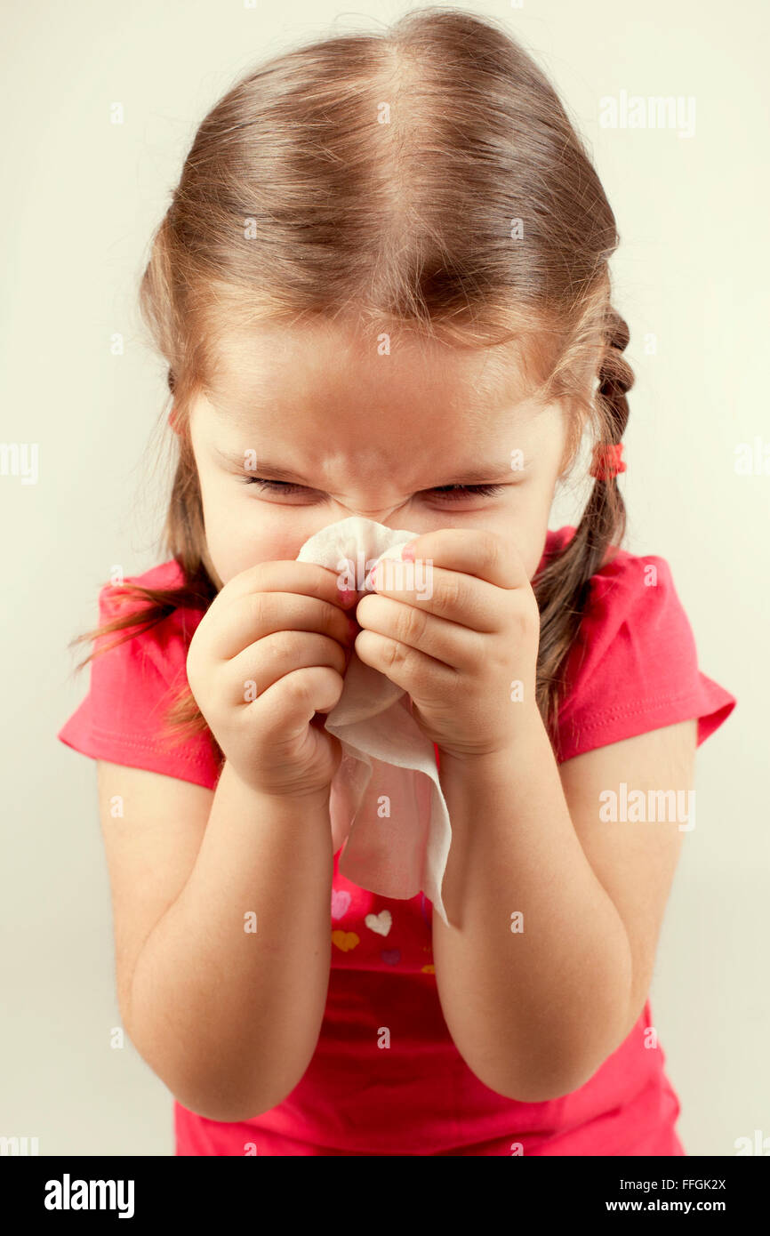 Mädchen wischt ihre Nase mit einem Taschentuch Stockfoto