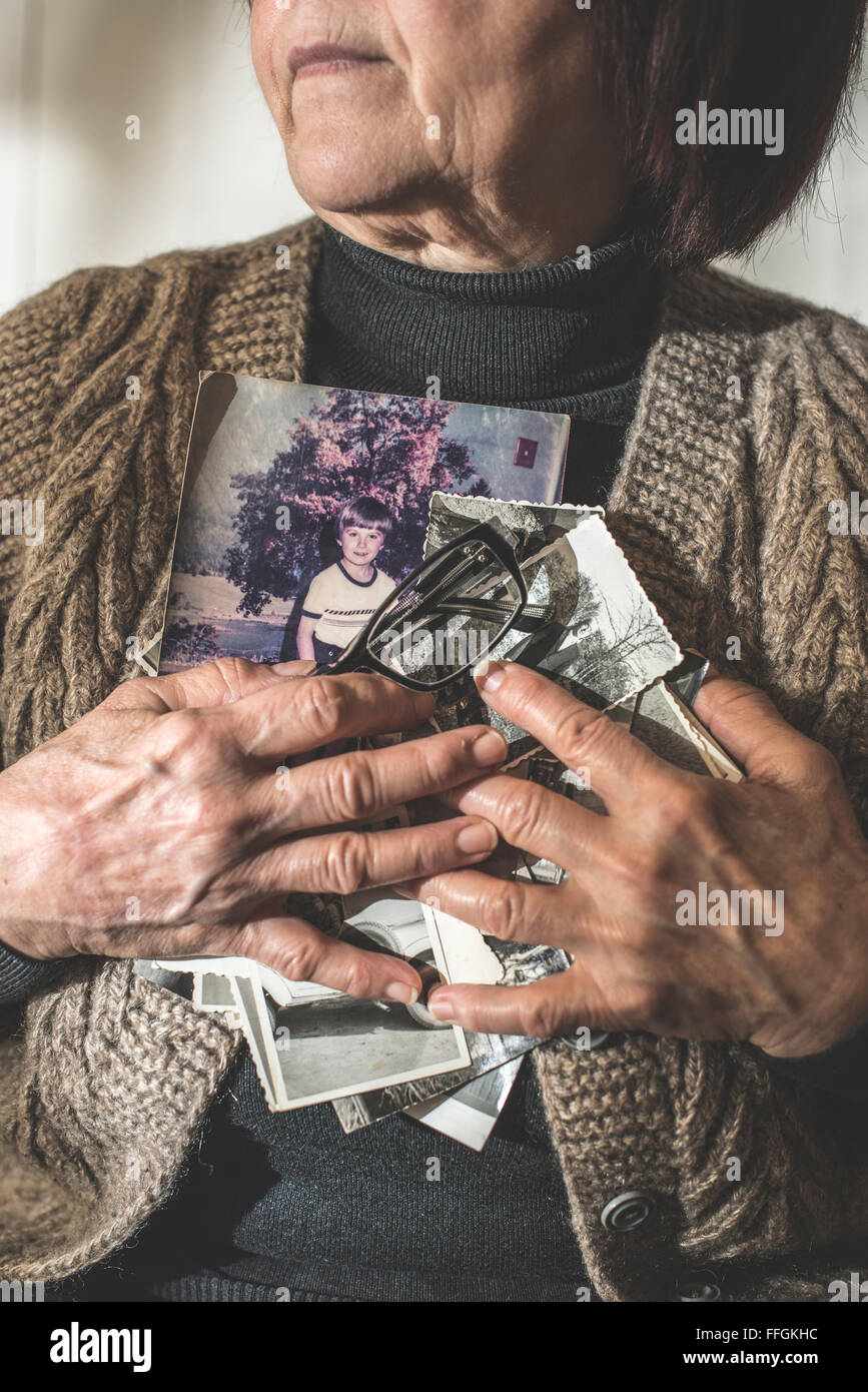 Ältere Frau halten Bilder der Kinder. Spielzeug Stockfoto