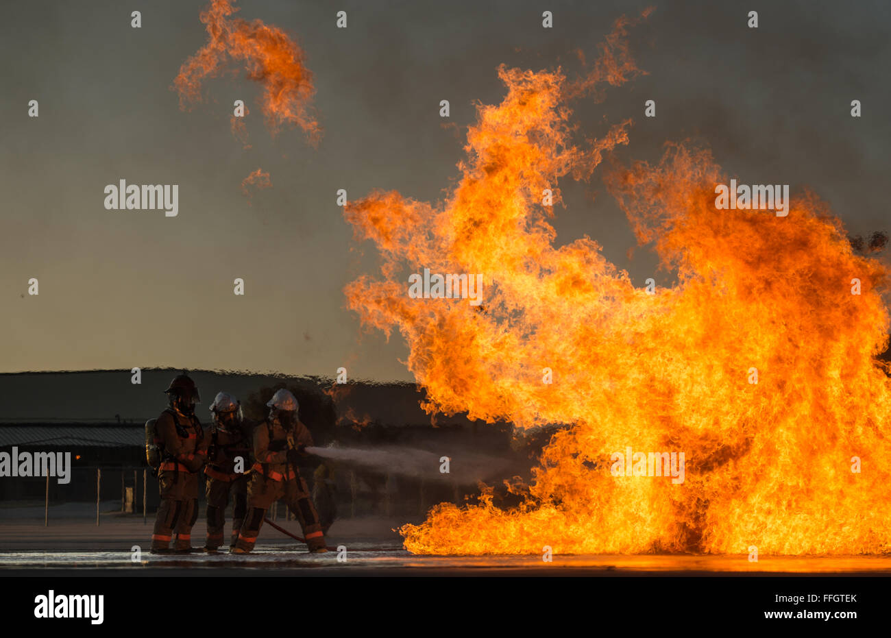 Drei militärischen Schüler zugewiesen, 312th Training Squadron Schlacht ein Feuer während ein flüssiges Feuer-Szenario an der Louis F. Garland Department of Defense Fire Academy, 15. Oktober 2015. Während des Trainings flüssiges Feuer drehen die Studenten durch 3-Mann-Iterationen der niedrigen und hohen Feuer während der Bewegung durch das Wasser. Die gemeinsame DOD-Schule besteht aus Luftwaffe, Heer, Marine, Marine und Zivildienst Studenten. Stockfoto