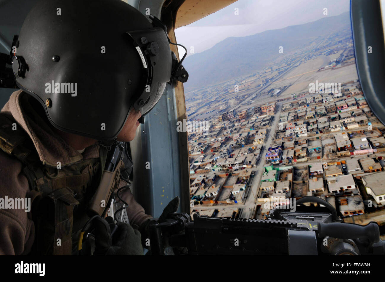 Techn. Sgt Jerry Sayasene, Flugingenieur mit der 438th Air Expeditionary Advisory Squadron, bietet Support für Gunner während eines Fluges zwischen Kabul und Jalalabad, Afghanistan. Sayasene ist derzeit eingesetzt, um die afghanischen Luftwaffe Flugingenieure am internationalen Flughafen von Kabul beratenden auszubilden. Stockfoto