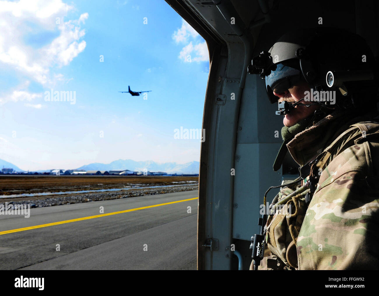 Senior Master Sgt. Todd Peplow, eine Antenne Schütze mit der 438th Air Expeditionary Advisory Squadron, mit Blick auf den internationalen Flughafen von Kabul Flightline nach Abschluss einen Flug zwischen Jalalabad und Kabul, Afghanistan. Peplow ist derzeit eingesetzt, um die afghanischen Luftwaffe Flugingenieure beratenden auszubilden. Stockfoto