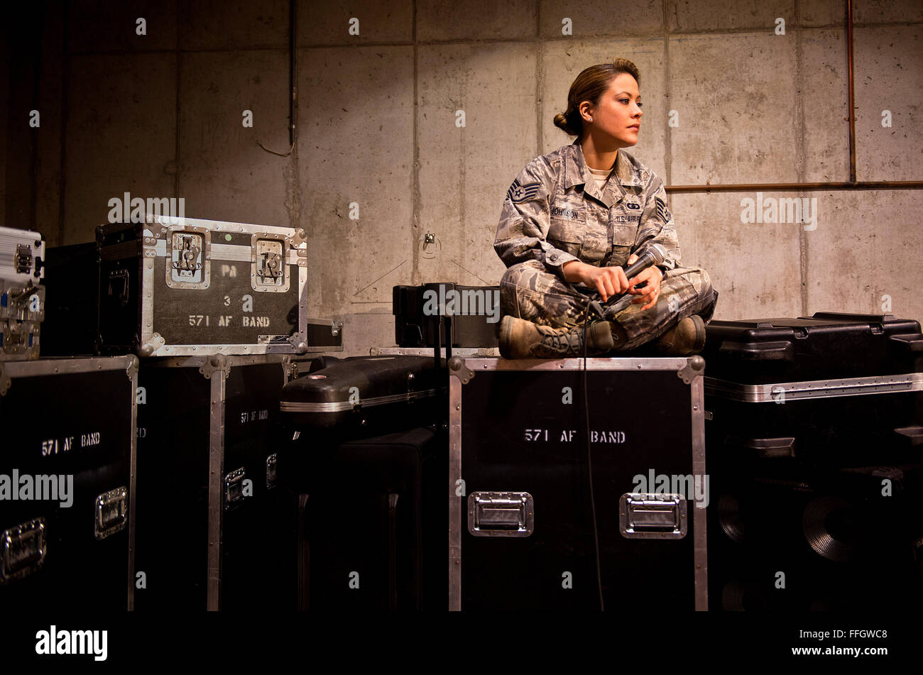 Staff Sgt Angie Johnson ruht auf 571st Air Force Band Ausrüstung Bereitstellung Fällen nach einer Probe mit Rock Ensemble Sidewinder. Johnson war mit Sidewinder, Südwestasien eingesetzt, wenn die Band gedreht wurde eine spontane Konzert für einige Flieger in der Nachtschicht durchführen. Johnson wurde über Nacht zur Sensation, nachdem die Band die Leistung von Adeles "Rolling In The Deep" wurde online gestellt. Stockfoto