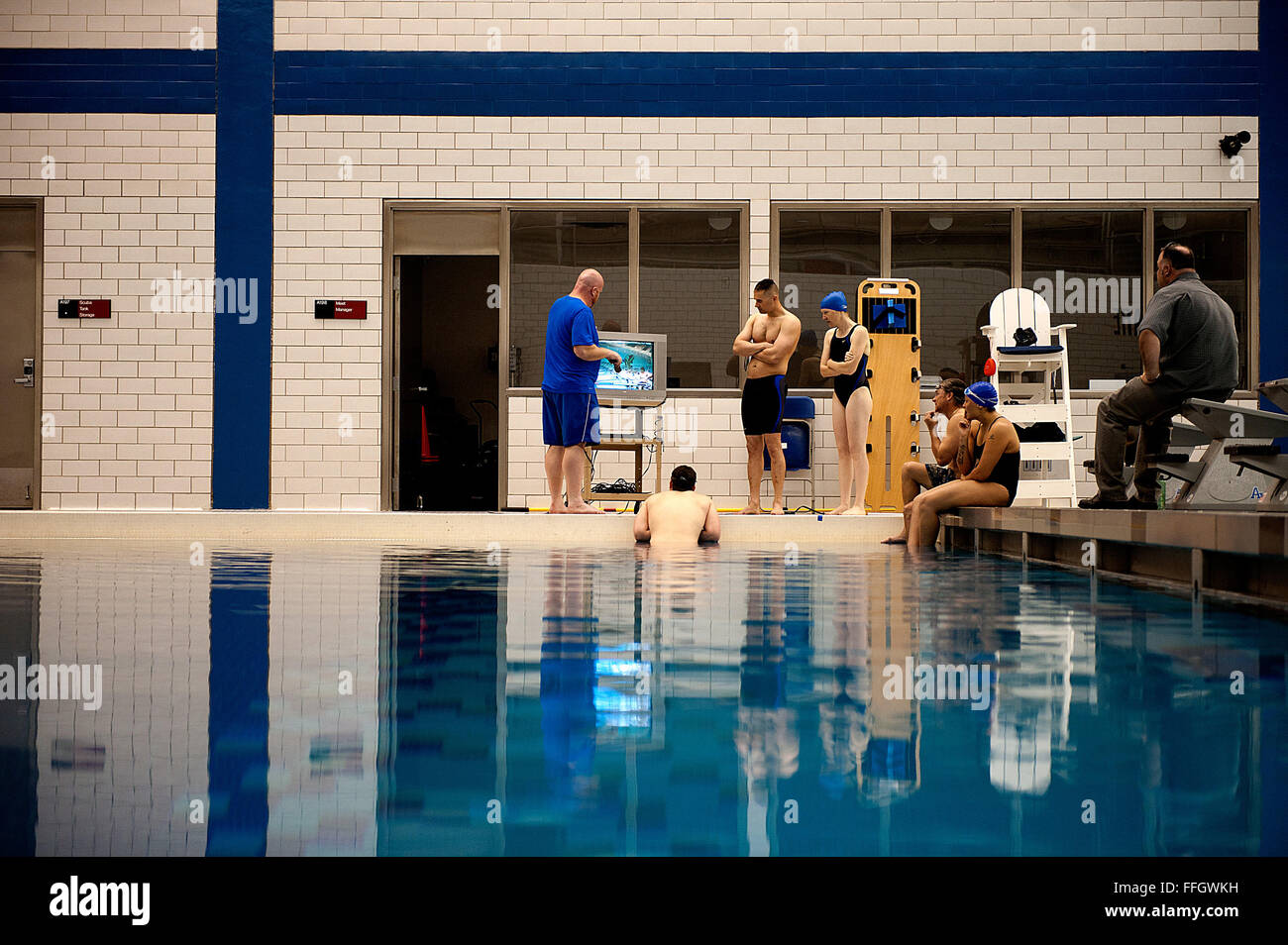 Air Force Warrior Spiele Schwimmen einberufene hören, wie ihr Trainer, Anthony Boettcher, geht über ein Video nahm er ihrer Praxis. Stockfoto