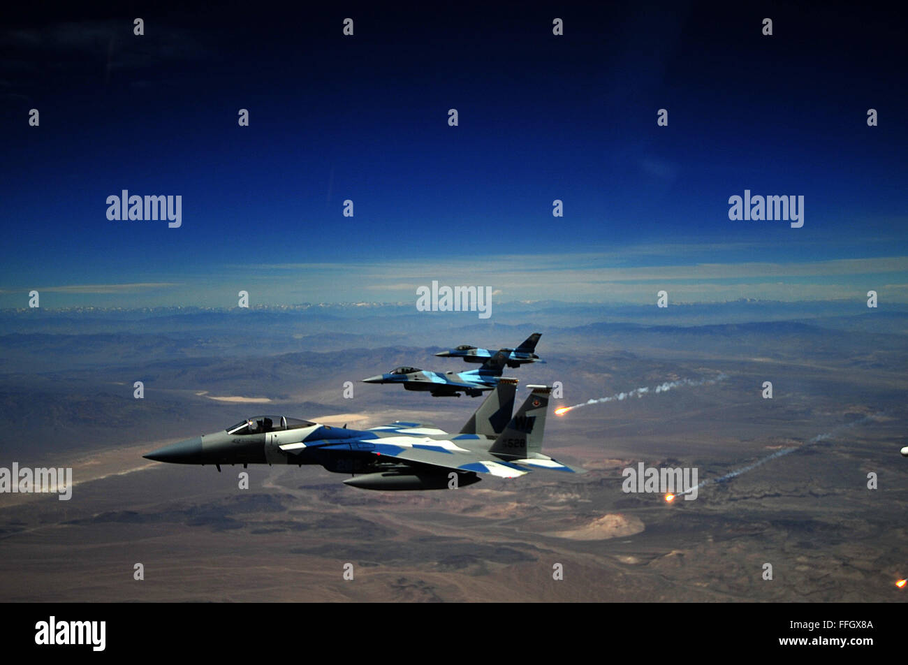 Eine F-15E Strike Eagle und zwei 65. Aggressor Geschwader f-16 Fighting Falcons fliegen in Formation nach einem Luftkampf gegen Mitglieder der Air Force Weapons School. Stockfoto