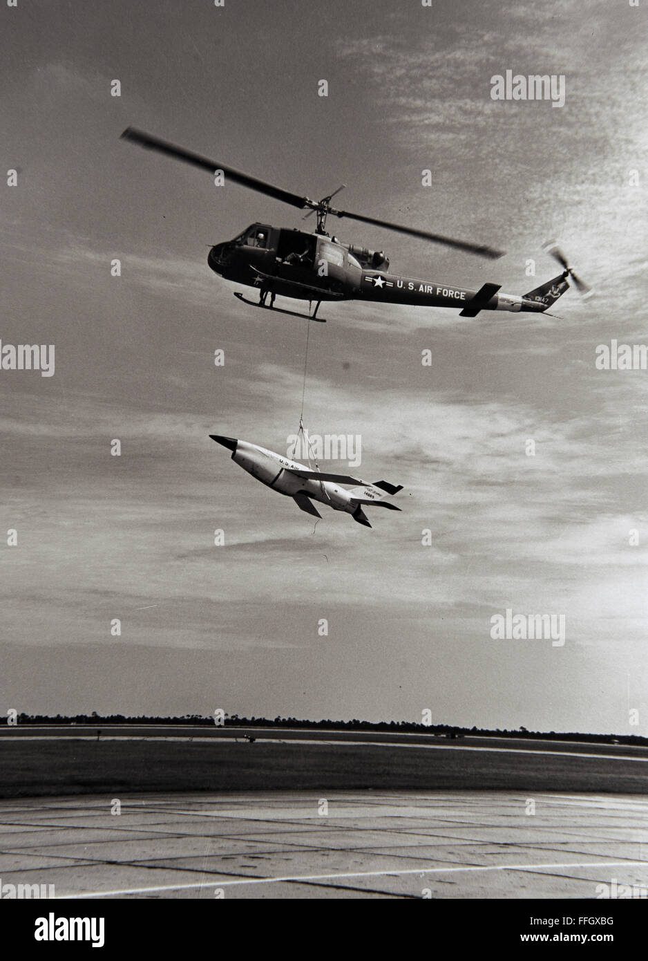 Ein Air Force UH - 1H Hubschrauber von Tyndall Air Force Base, Florida, senkt eine Jet-Drohne auf den Boden nach der Wiederherstellung der Test-Drohne aus dem Golf von Mexiko 1969. Stockfoto