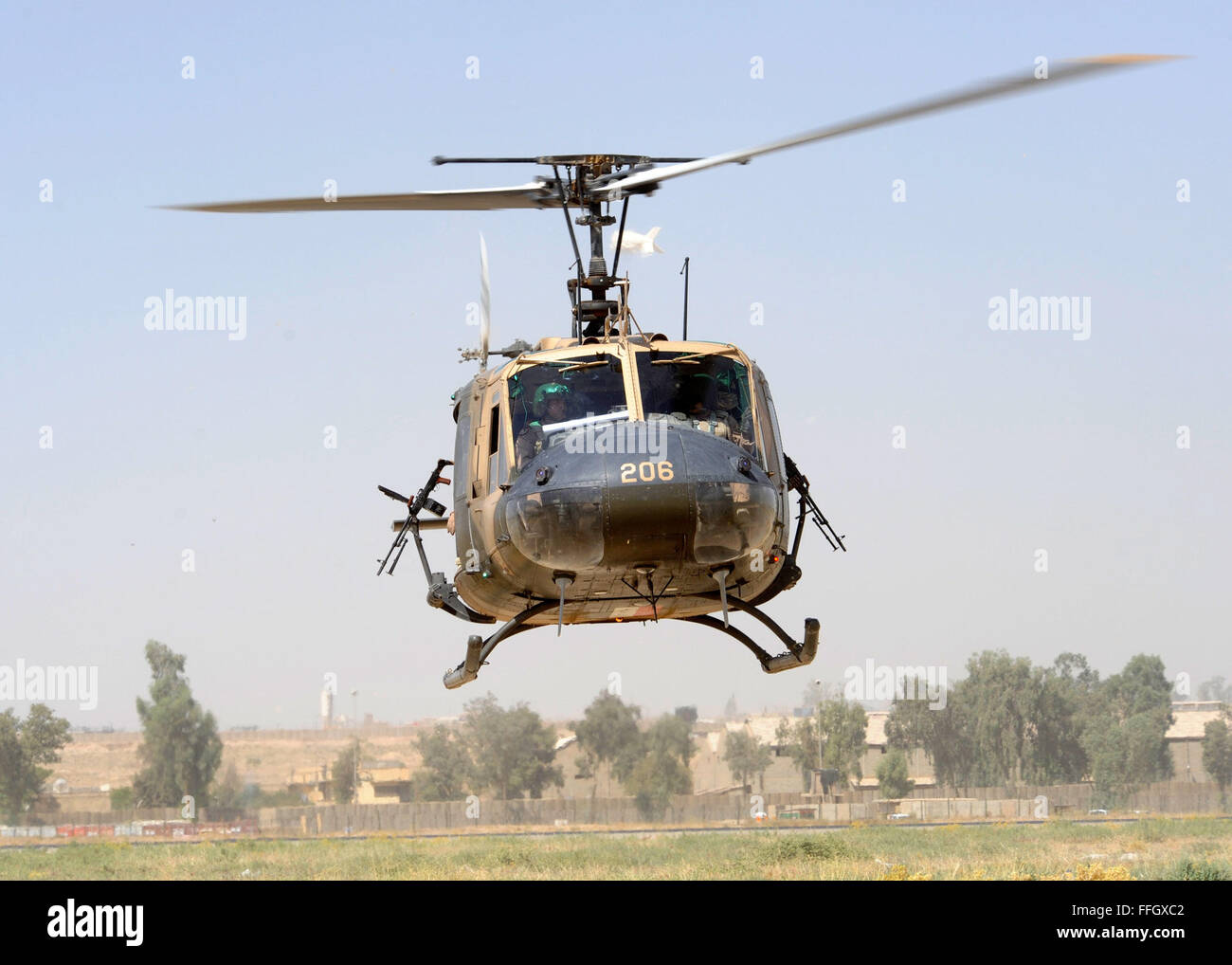 Eine irakische Luftwaffe sichert UH - 1 H Weg, wie es sich taxis vor dem Start auf eine gemeinsame Mission über den Irak, auf Forward Operating Base Diamondback in Mosul, Irak. Stockfoto
