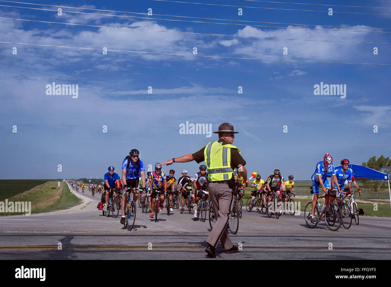 Iowa State Patrol Officer regelt den Verkehr während der RAGBRAI. Die Route für RAGBRAI ist meist geschlossen, Kfz-Verkehr, sondern in mehreren Bereichen, die der Weg Autobahnen überquert, die nicht vermieden werden kann. Zur Gewährleistung der Sicherheit der Staat zur Verfügung gestellt Patrouille Offiziere zur Steuerung der grenzüberschreitende Verkehr Stockfoto