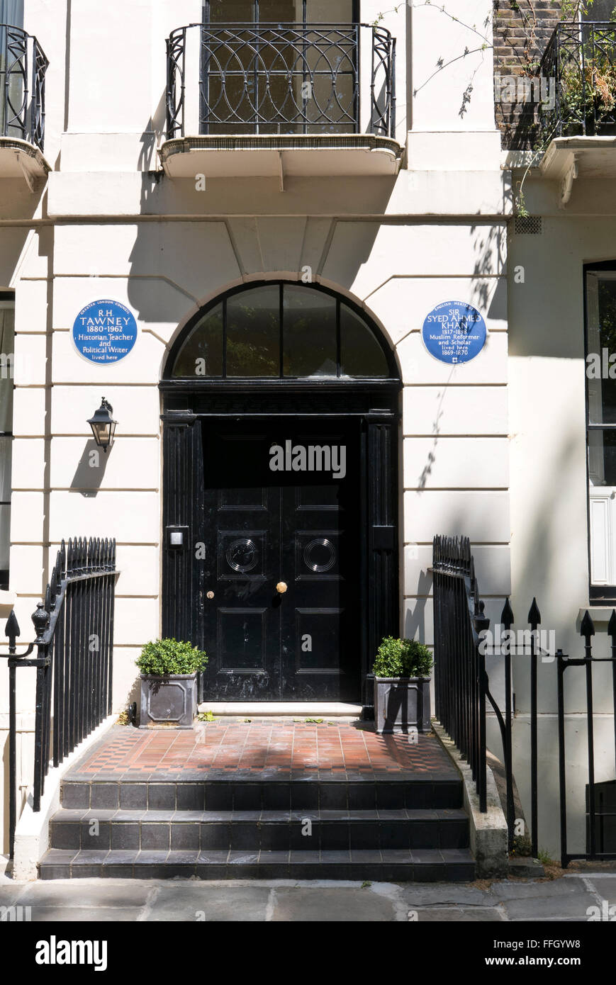 Zwei blaue Gedenktafeln mit den Namen von R.H Tawney und Sir Syed Ahmed Khan auf dem Display an einer Wand in London, UK. Stockfoto