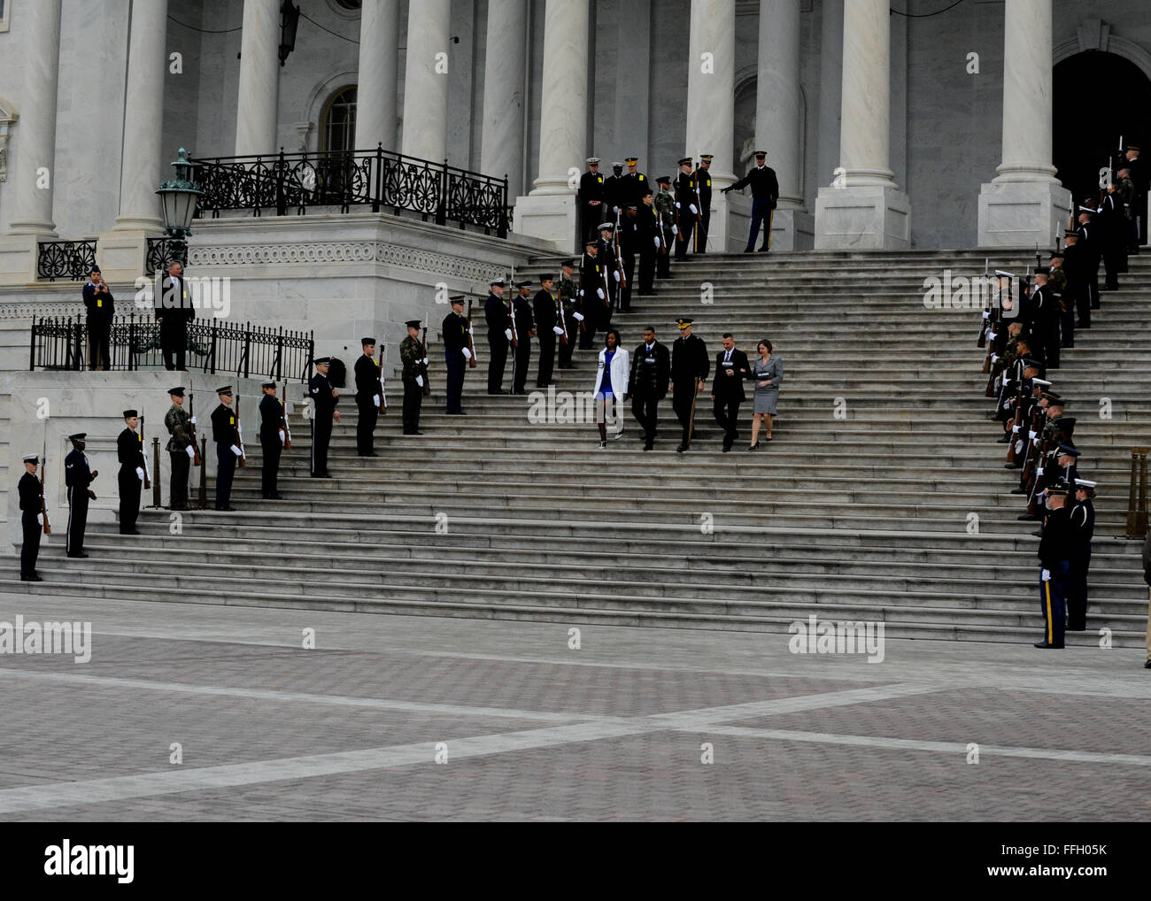 Eine gemeinsame Ehre wache salutiert als Rollenspieler vertritt der Präsident, Vizepräsident und deren Ehegatten steigen die U.S. Capitol Schritte während der Amtseinführung Generalprobe in Washington, D.C. Stockfoto