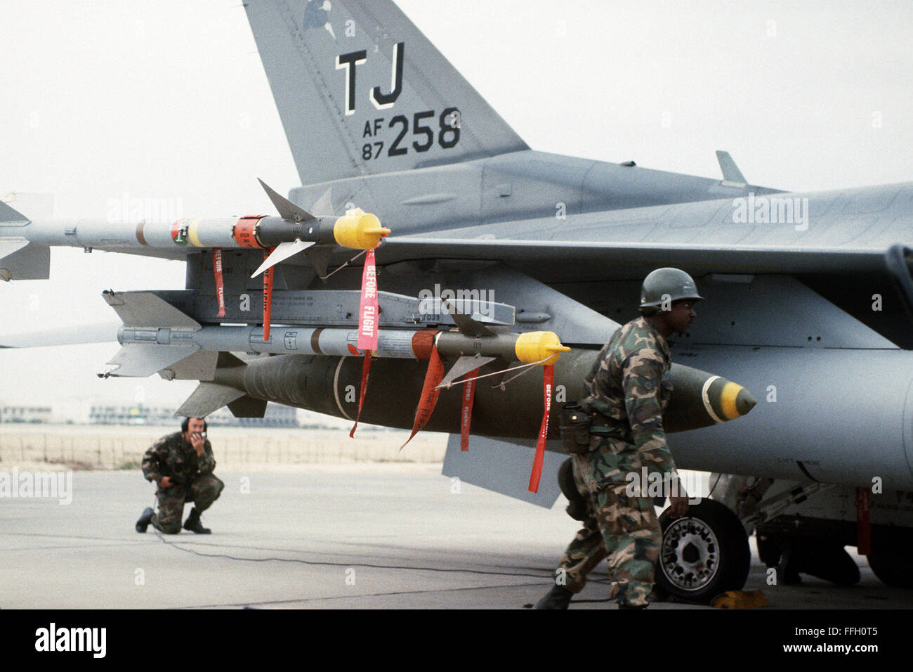 Mitglieder der 401. Aircraft Generation Squadron laden Artillerie auf einem 401st Tactical Fighter Wing F - 16C Fighting Falcon Flugzeuge in Vorbereitung für den ersten Tageslicht-Streik gegen irakische Ziele während der Operation Desert Storm.  Die F-16 C ist mit AIM-9 Sidewinder-Raketen und eine Mark 84 2.000 Pfund Bomben bewaffnet. Stockfoto