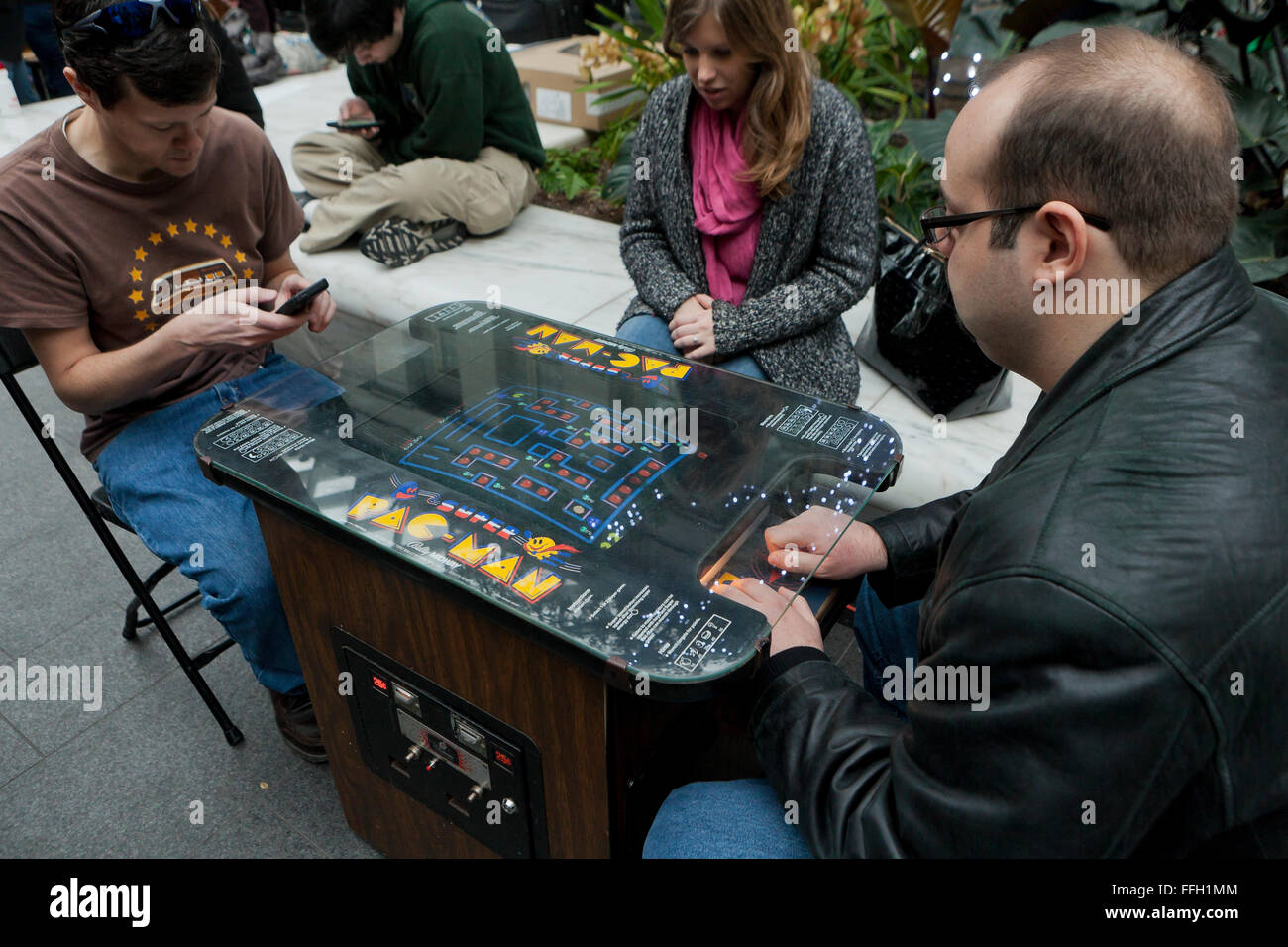Menschen spielen eine Vintage Pac-Man-Video Arcade-Spiel - USA Stockfoto