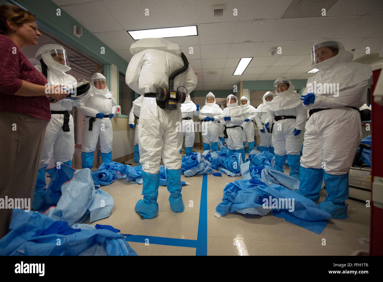 Mitglieder einer militärischen Ebola medizinische Unterstützung Teamübung anlegen persönlichen Schutzausrüstung während einer einwöchigen Fortbildungsveranstaltung an San Antonio Military Medical Center in San Antonio. Das Training wurde entwickelt, um sie darauf vorzubereiten, Wunsch, zivile Mediziner in den Vereinigten Staaten zu unterstützen. Die Hälfte des medizinischen Personals sind von der Armee und sechs aus der Air Force und neun von der Marine. Die Trainer kommen aus der US-Armee medizinische Forschung Institut für Infektionskrankheiten in Frederick, Maryland. Stockfoto