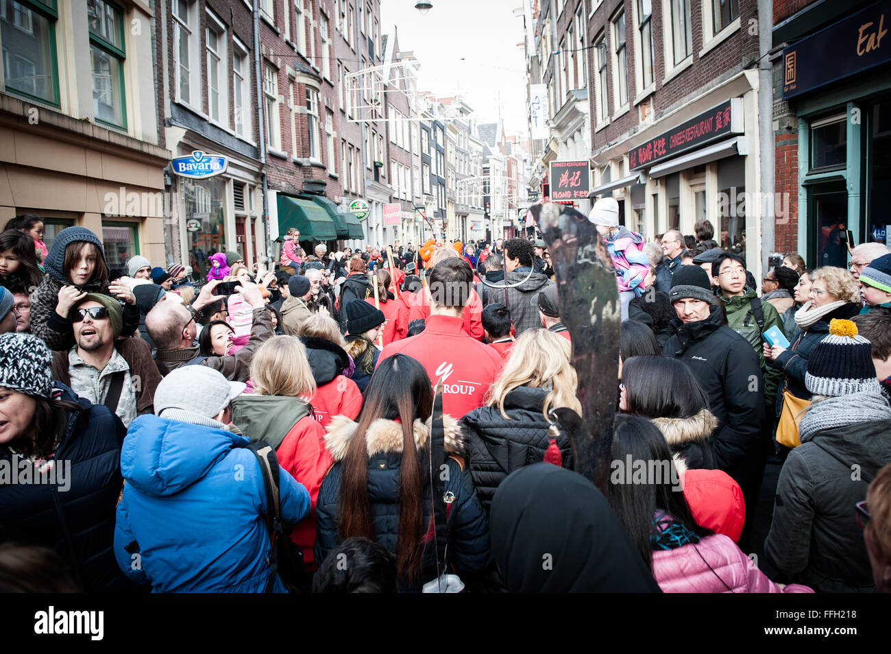 Amsterdam, Niederlande. 13. Februar 2016. Lion Tänzer zu besuchen, die Häuser und Geschäfte von der chinesischen Gemeinschaft den traditionellen Brauch der auszuführenden "cai Qing", eine Quest von dem "Löwen", das verheißungsvolle grün "Gemüse" wie Salat und verheißungsvolle Früchte wie Orangen pflücken gebunden an einen "roten Umschlag" mit Geld. Der Löwentanz wird geglaubt, um Glück und Wohlstand für das Unternehmen zu bringen. Die Truppe ist mit dem roten Umschlag belohnt. Bildnachweis: Romy Arroyo Fernandez/Alamy Live-Nachrichten. Stockfoto